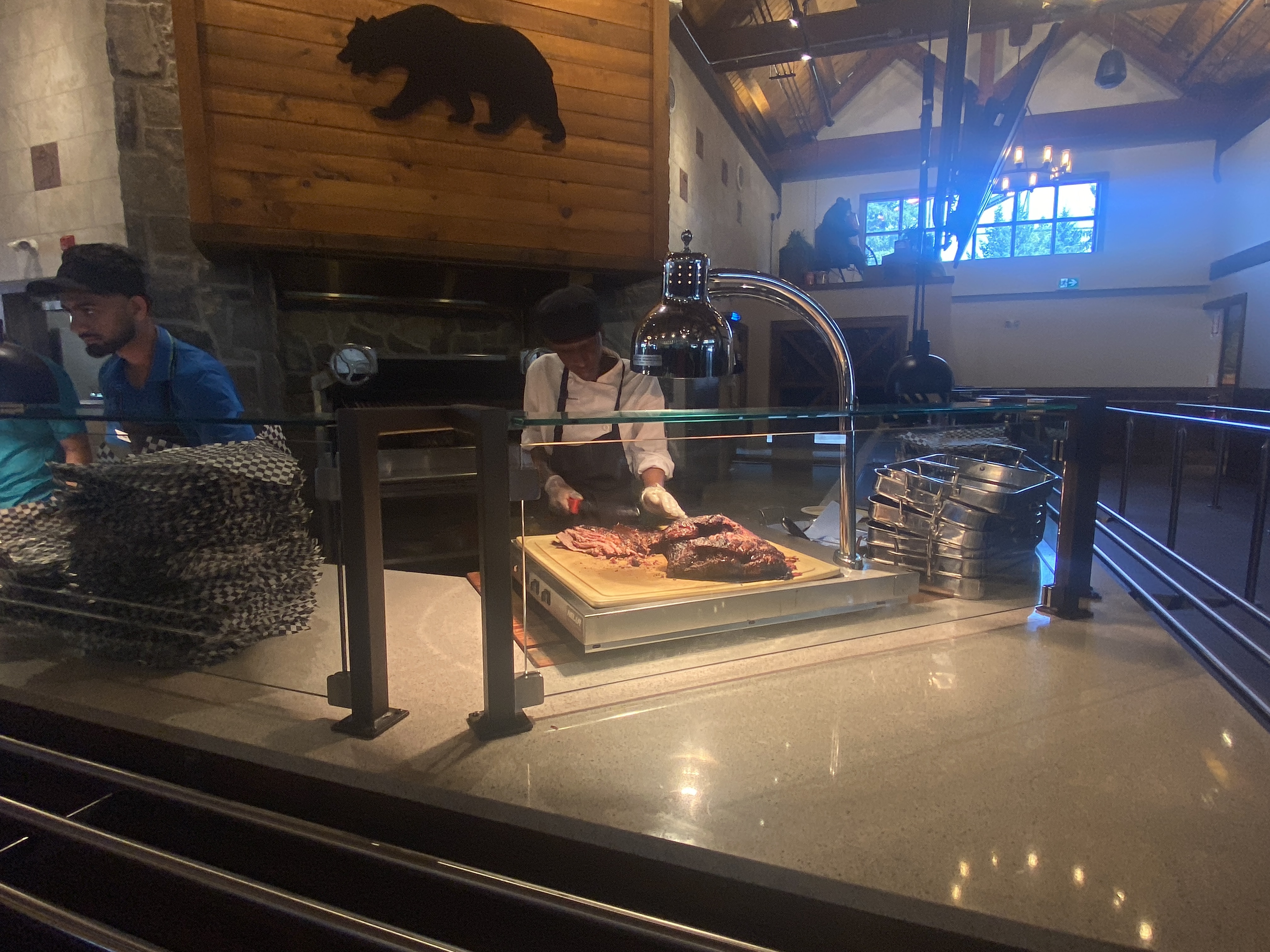 The cook is carving the beef brisket in front of guests.